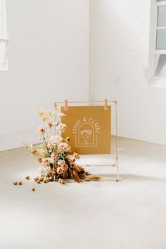 an arrangement of flowers on the floor next to a sign