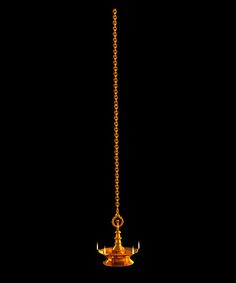 a golden chandelier hanging from a chain on a black background with the lights turned on