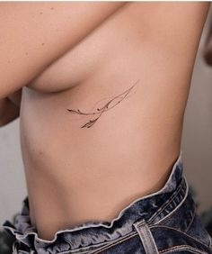 a woman's stomach with a small tattoo on her left side, and an arrow in the middle