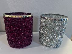 two glitter cups sitting next to each other on a table