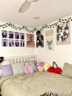 a bed room with a neatly made bed and many pictures on the wall above it