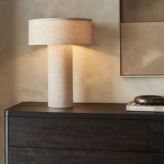 a table lamp sitting on top of a wooden dresser