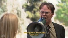 a man with glasses is holding a megaphone in front of a woman's face