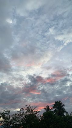 the sky is filled with pink and blue clouds as the sun sets in the distance