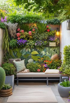 an outdoor garden with lots of plants on the wall and couches in the middle