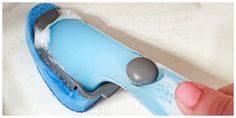 a person is using a blue and gray brush to clean the surface of a toilet