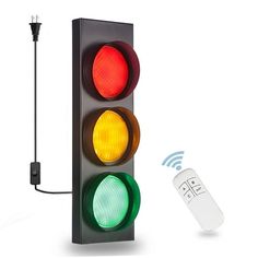 a traffic light with a remote control attached to it's side and an electronic device connected to the stoplight