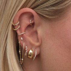 a close up of a woman's ear with three different types of piercings