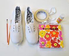 a pair of white shoes sitting on top of a table next to a package and scissors