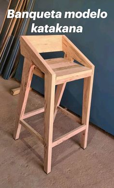 a wooden stool sitting in front of a blue wall