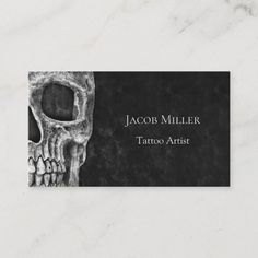 a black and white business card with a skull on the front, which reads your tattoo business