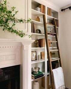 a ladder leaning up against a bookshelf in a living room with white walls