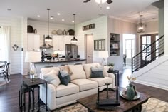 a living room filled with furniture next to a kitchen and breakfast nook area on top of a hard wood floor