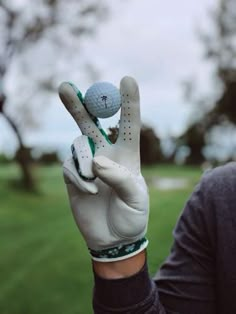 a man holding up a golf ball and glove