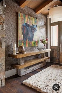 a living room with a large painting on the wall and a rug in front of it