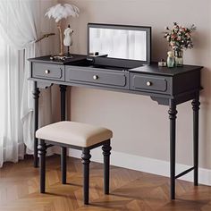 a desk with a mirror, stool and flower vase on the table in front of it