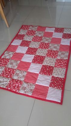 a red and white quilt is laying on the floor