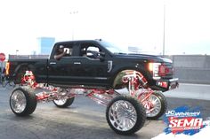 a black truck with chrome rims and big tires