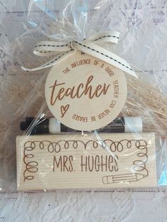 a wooden sign that says teacher is on top of a piece of wood with writing