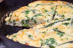 an omelet with spinach and cheese is being cooked in a skillet