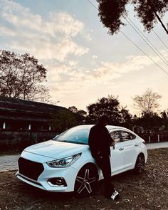 a man standing next to a white car