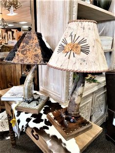 a lamp that is sitting on top of a table next to a cowhide rug