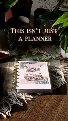 this isn't just a planner book on a wooden table next to potted plants