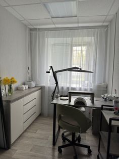 a room with a desk, chair and window