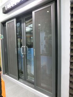 a man standing in front of a building with lots of glass doors on the outside