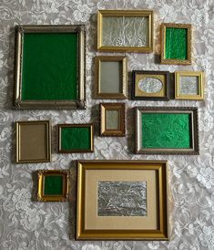 there are many different frames on the table together, including one with green and gold paint