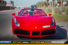 a red sports car is parked on the side of the road with palm trees in the background