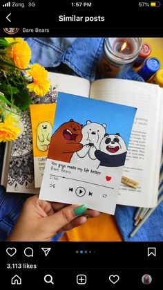 someone is holding up an open book with pictures of bears and pandas on it