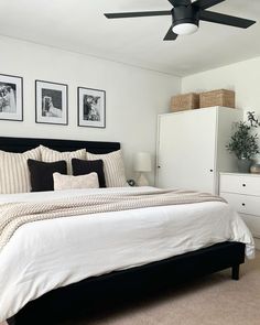 a bedroom with a bed, dresser and two pictures on the wall above it's headboard