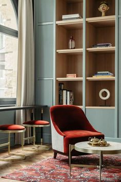 a living room filled with furniture and bookshelves in front of a large window