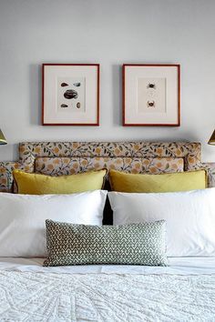 a bed with two lamps on either side of the headboard and pillows in front of it