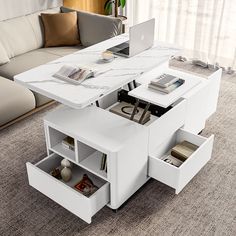 a white coffee table with open drawers and a laptop computer on it in a living room