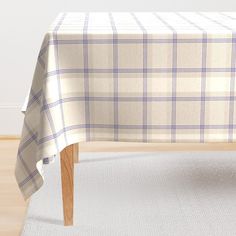 a table with a white and blue checkered cloth on it, sitting in front of a wall