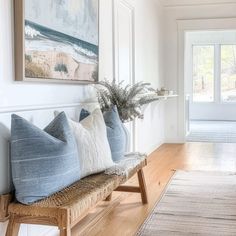 a wooden bench sitting next to a white wall