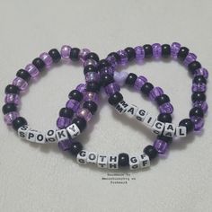 three purple and black beaded bracelets with words on them