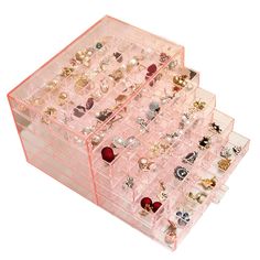 two clear acrylic boxes with earrings in them on top of each other,