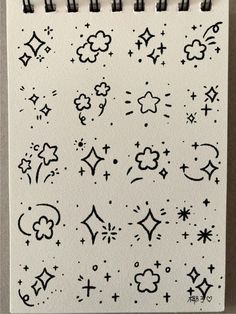 a notebook with black ink on it and stars, clouds, and moon symbols in the middle