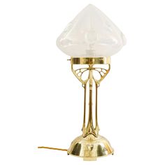 a brass table lamp with a glass shade