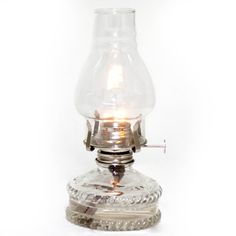 an old fashioned glass oil lamp on a white background