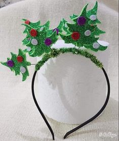 a white headband with green and red christmas trees on it, sitting on top of a white surface