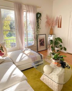 a living room filled with lots of furniture and plants on top of it's tables