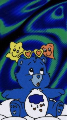 a blue teddy bear with hearts on its head and two other bears sitting behind it