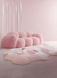 a pink couch sitting on top of a white rug