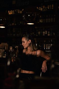 a woman sitting at a bar in the dark