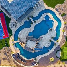 an aerial view of a tennis court and swimming pool in the middle of a park