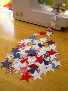 a pile of red, white and blue stars sitting on top of a wooden floor